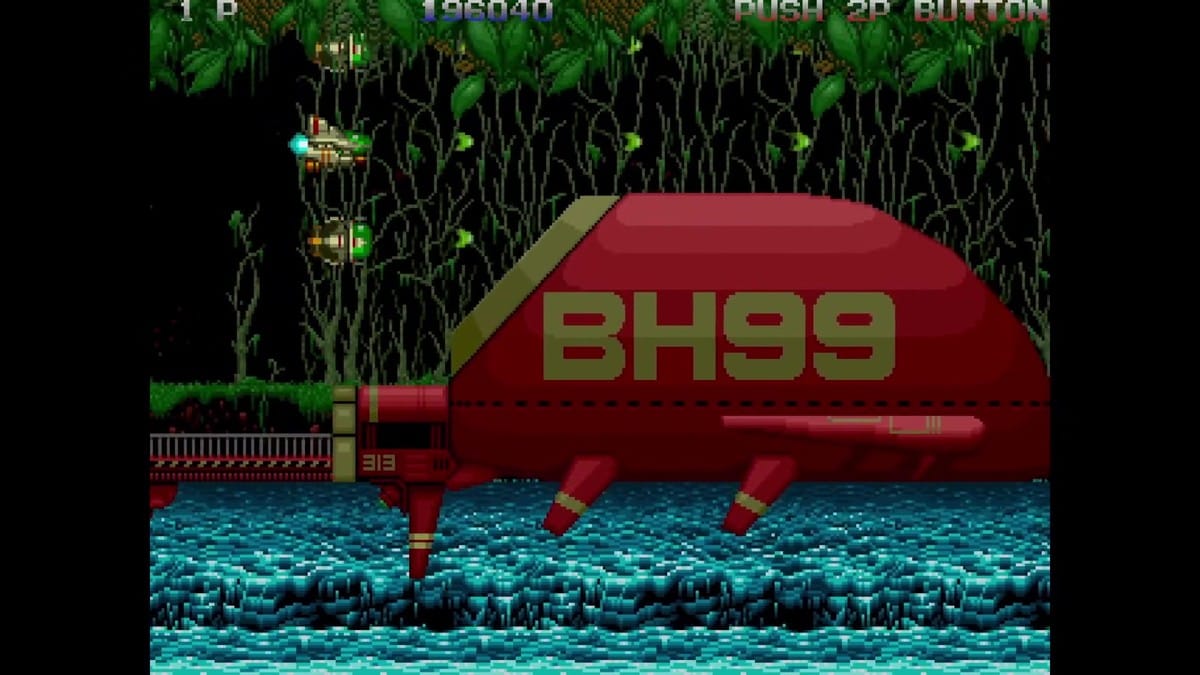 The player ship flies above the water past the massive red 'BH99' submarine structure.