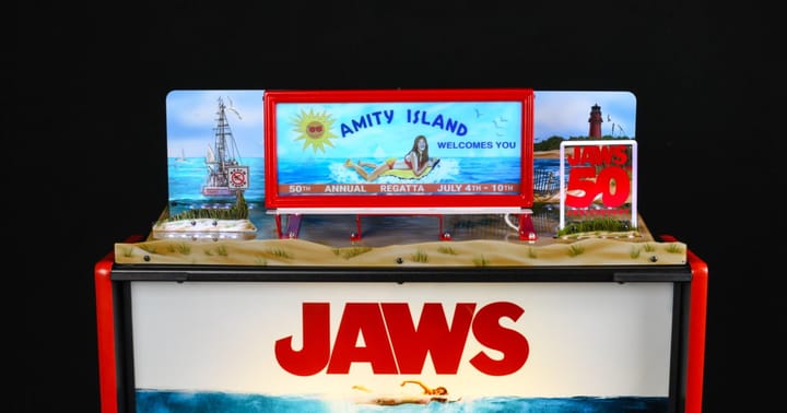 The JAWS 50th Anniversary Amity Island Billboard Topper mounted on a pinball machine.
