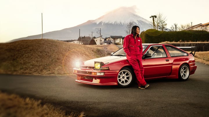 Actor Sung Kang standing next to a customized yellow car for the Forza Horizon 6 sweepstakes