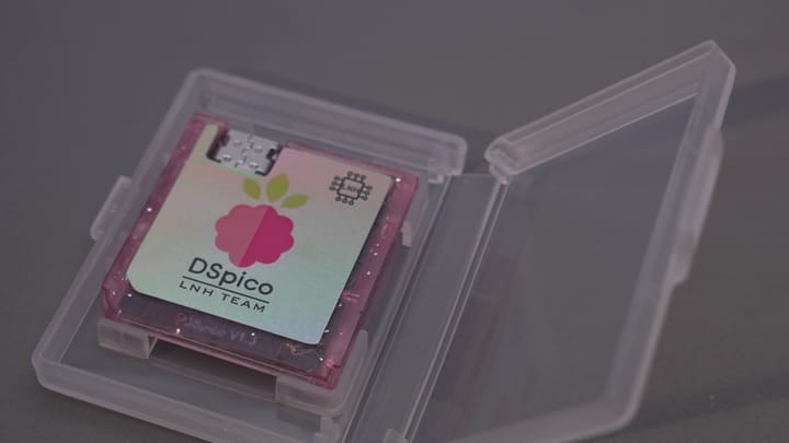 A close-up of the DSPico flashcart circuit board next to a Nintendo DS